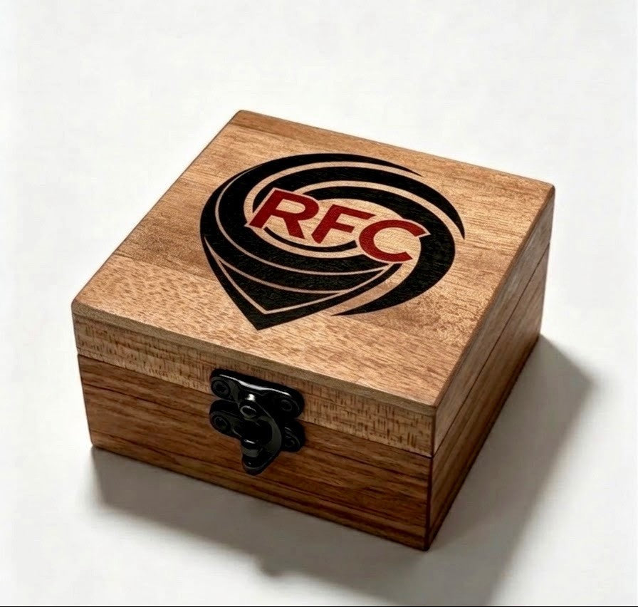 A square wooden keepsake box with a black metal latch, featuring a printed black logo with the red letters 'RFC' on the lid, set against a plain light background.