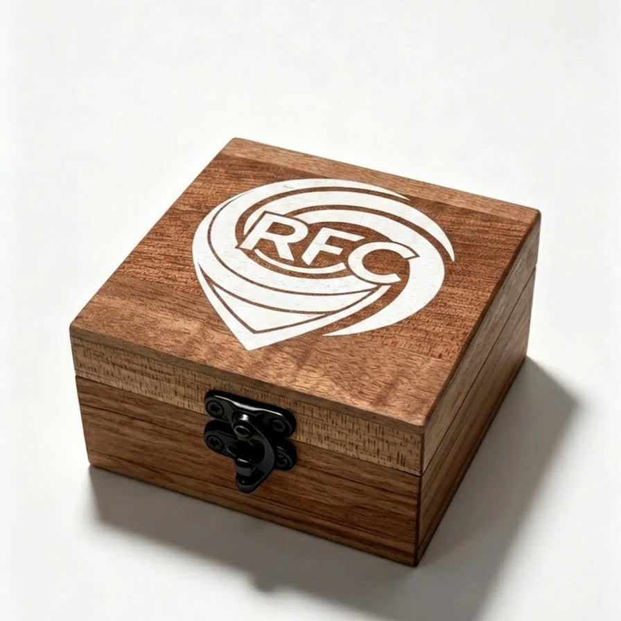 A square wooden keepsake box with a dark brown wood grain finish, featuring a white RFC logo on the lid and a black metal latch on the front, set against a plain white background.
